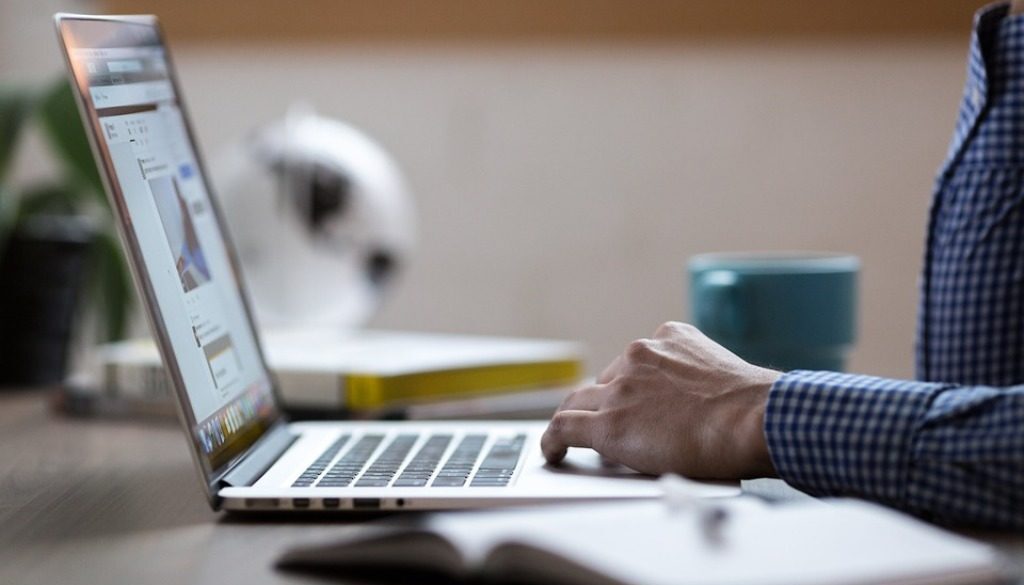 mani che scrivono su computer