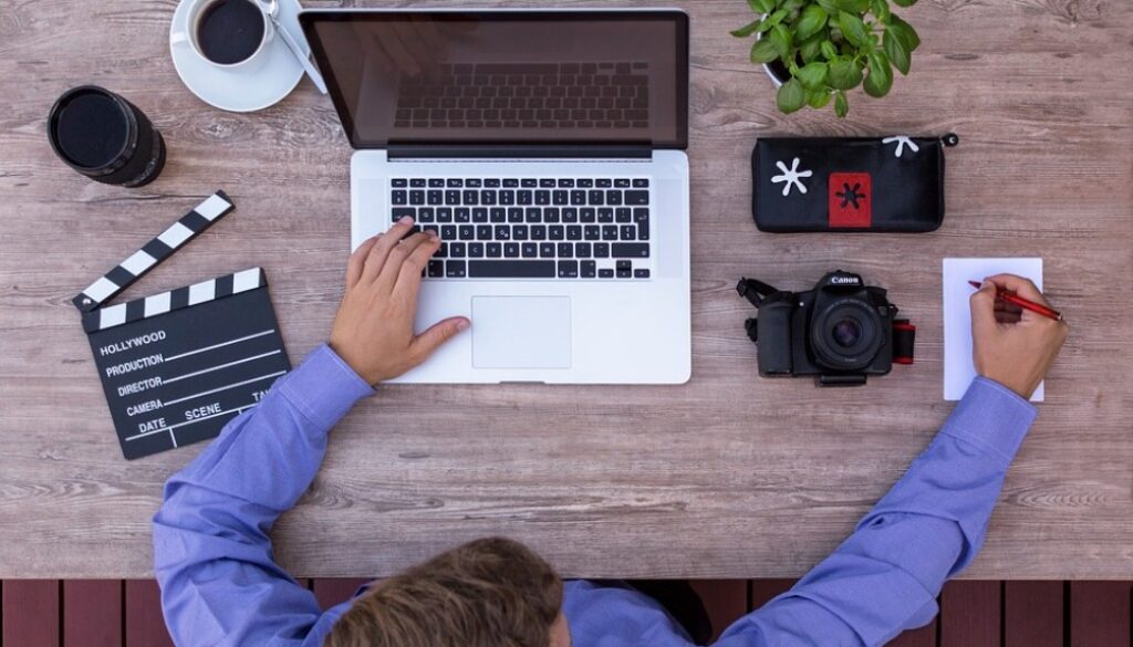 persona al computer, macchina fotografica, ciack