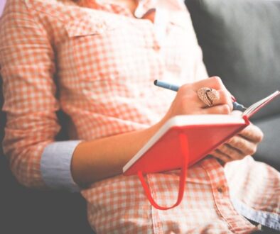 ragazza che scrive su un quaderno rosso