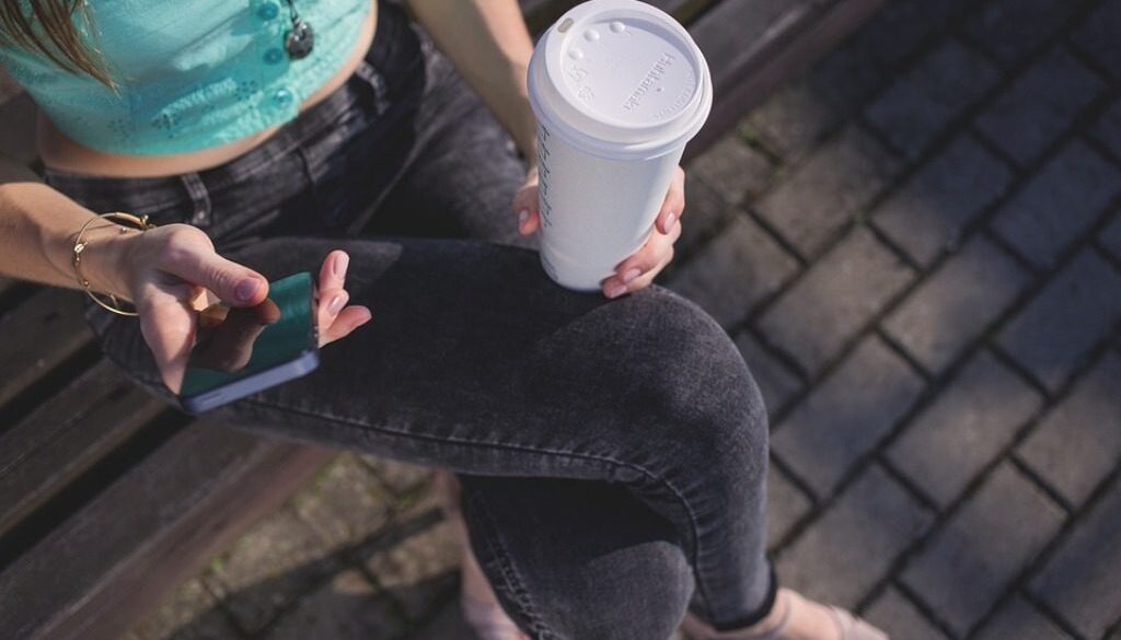ragazza con telefono e caffè