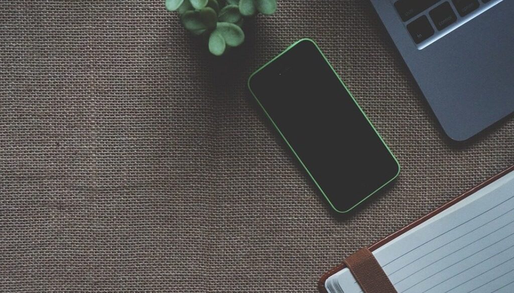 scrivania con smartphone, tastiera, tazza, agenda