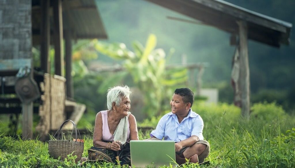 bambino e anziana davanti a un computer portatile