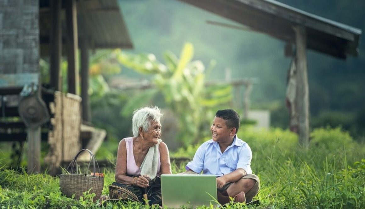bambino e anziana davanti a un computer portatile