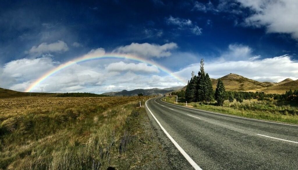 strada di campagna con arcobaleno all'orizzonte