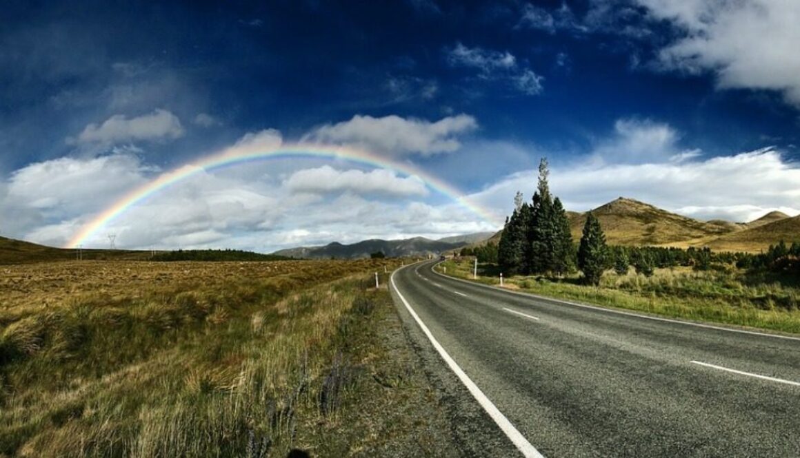 strada di campagna con arcobaleno all'orizzonte