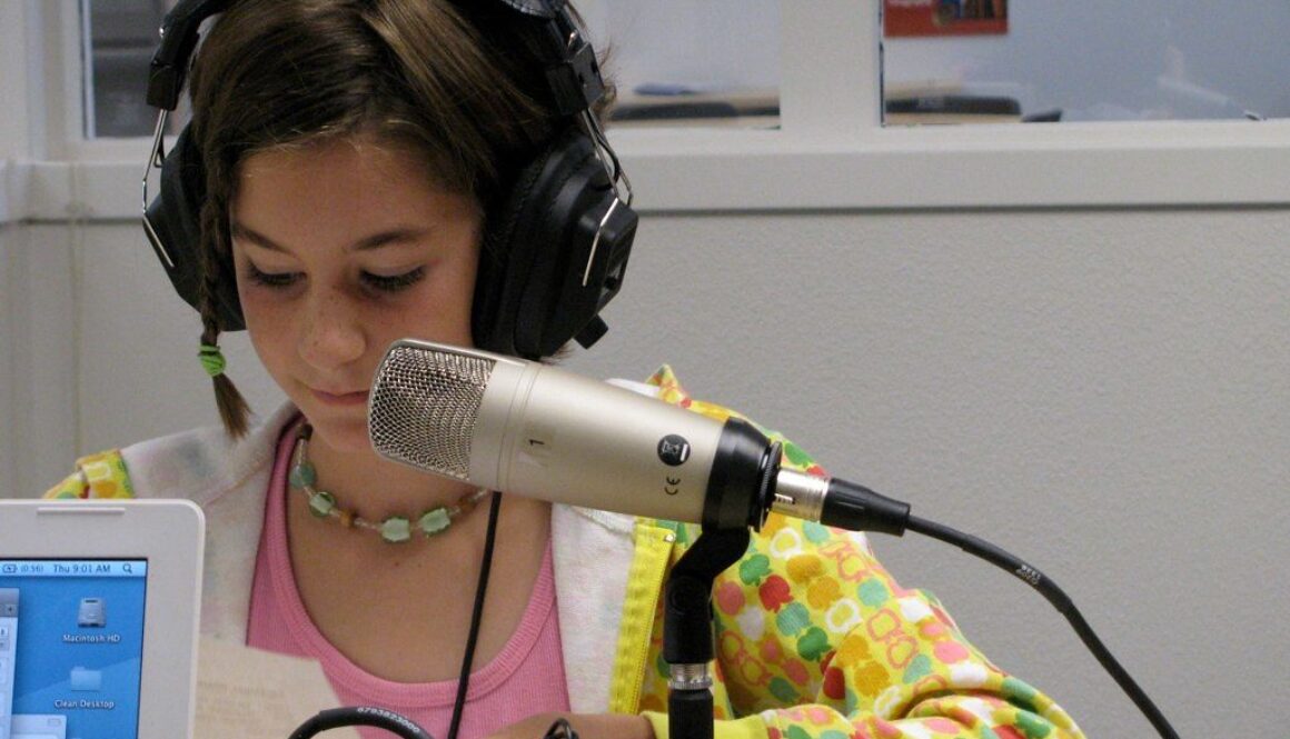 Elementary student being recorded with a microphone as part of a student produced podcast