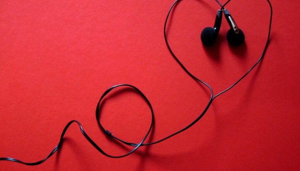 cuffiette nere a forma di cuore su fondo rosso. Ascoltare audiolibri gratuitamente