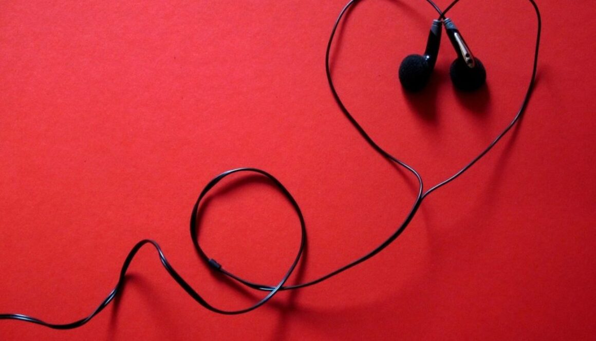 cuffiette nere a forma di cuore su fondo rosso. Ascoltare audiolibri gratuitamente