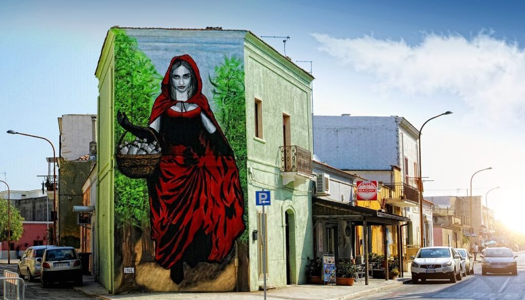 muyrales su facciata di casa che rappresenta donna cappuccetto rosso