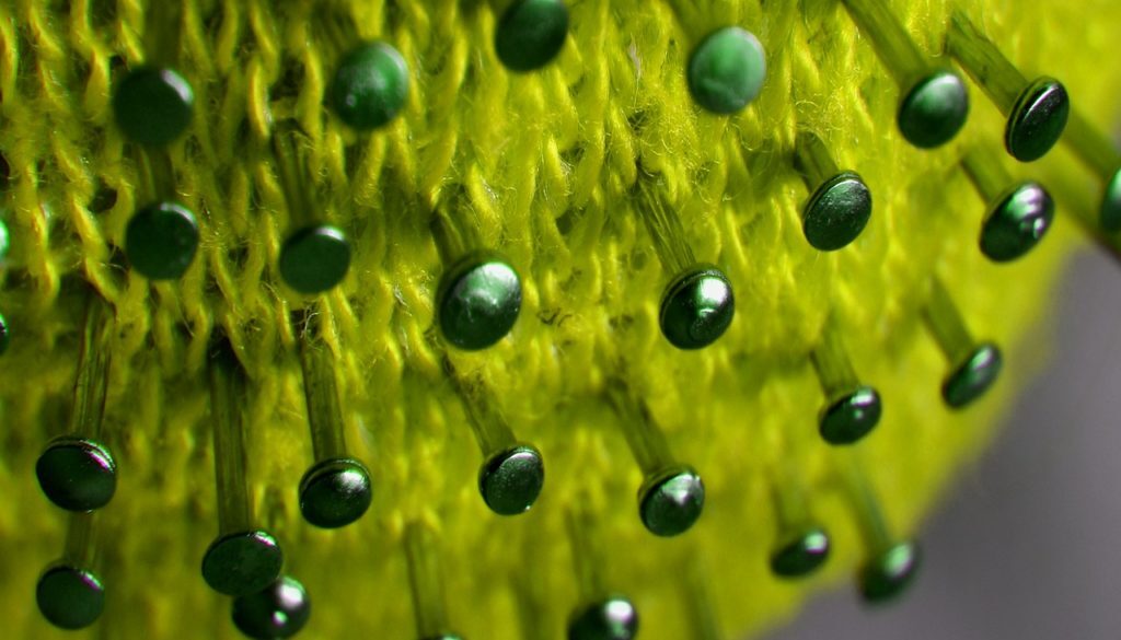 lavoro a maglia con spilli che rappresenta un coronavirus