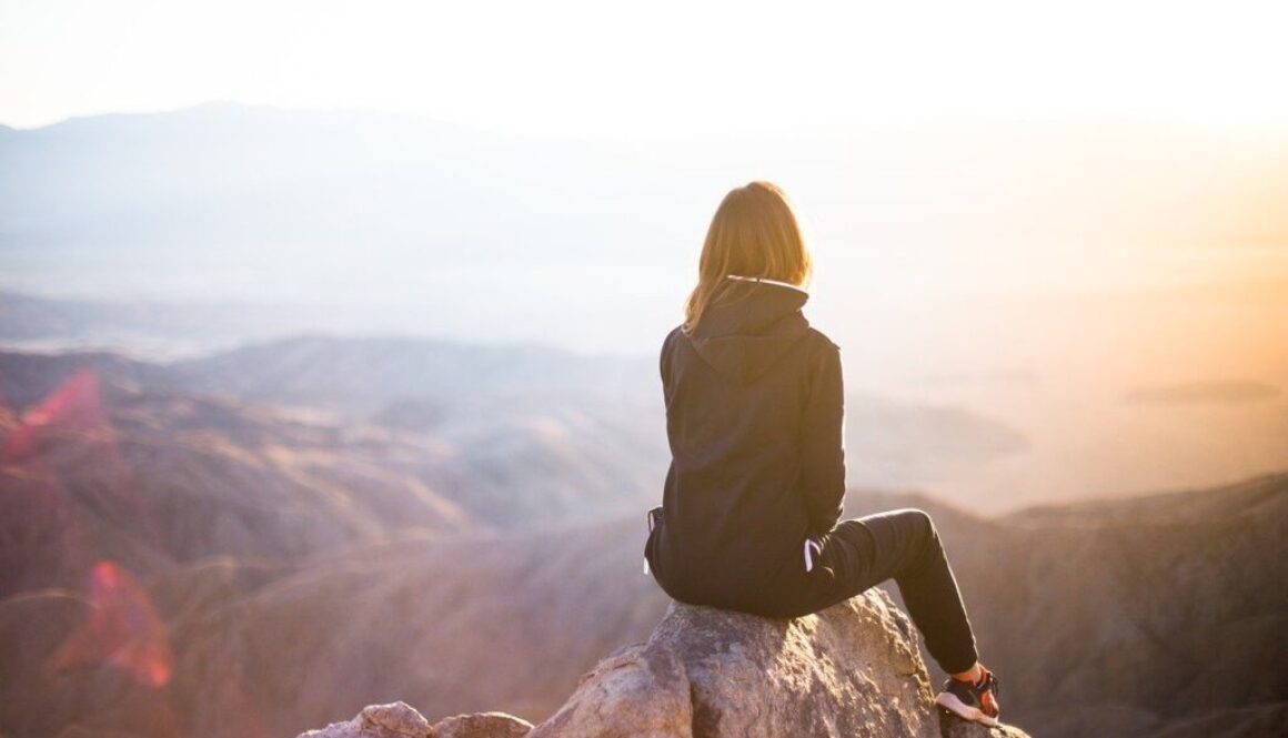 ragazza sulla cima di una montagna che guarda il panorama