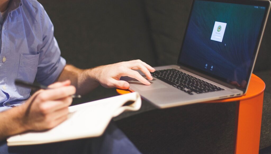 impiegato con computer che prende appunti