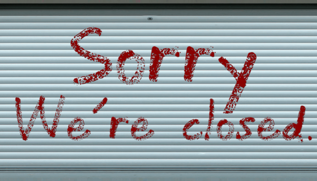 saracinesca di negozio con scritta spiacenti siamo chiusi