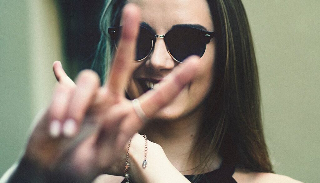 primo piano di ragazza che fa segno vittoria