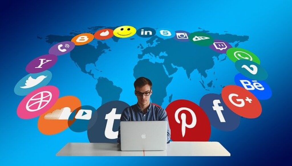 social media manager con computer e grafica con loghi dei social