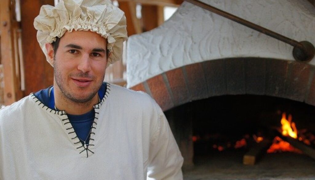 fornaio davanti al suo forno a legna