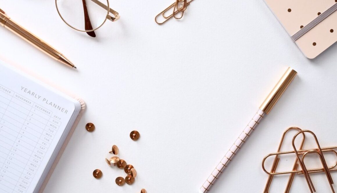 scrivania con puntine, graffette, agenda, occhiali