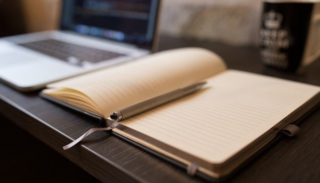 scrivania con computer e agenda