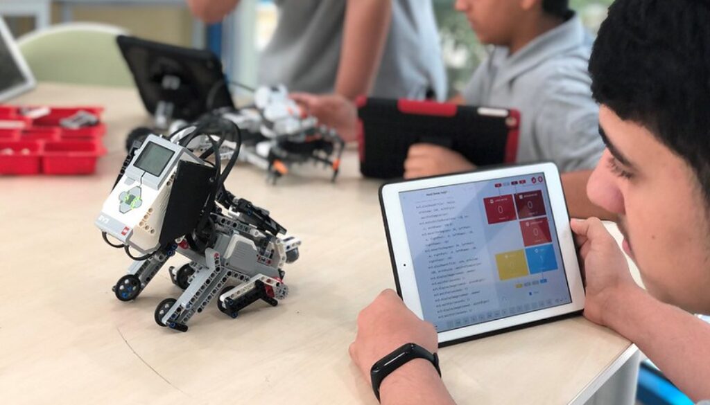 A student programming his robot puppy using an iPad