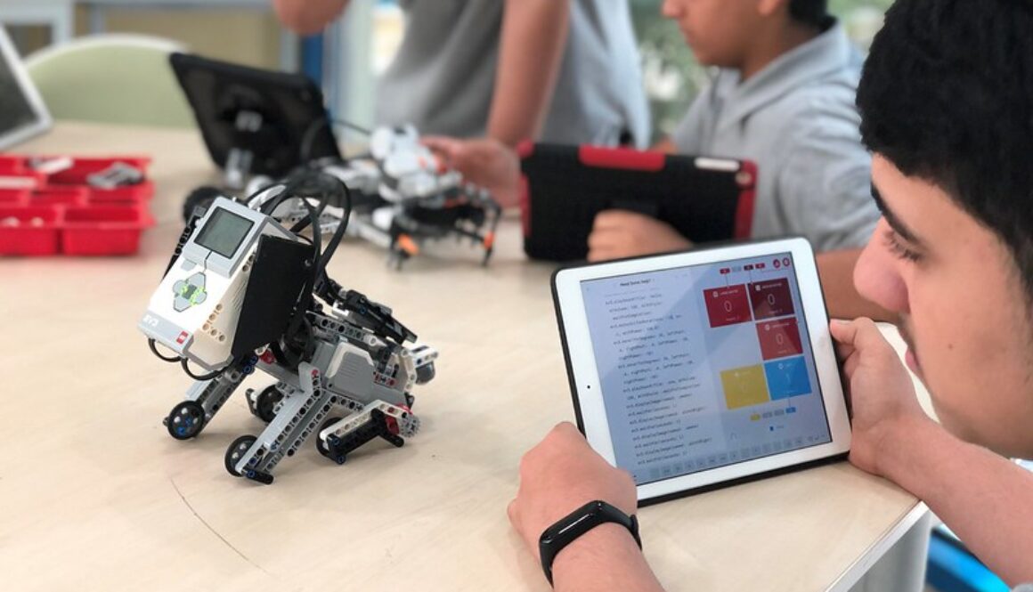 A student programming his robot puppy using an iPad