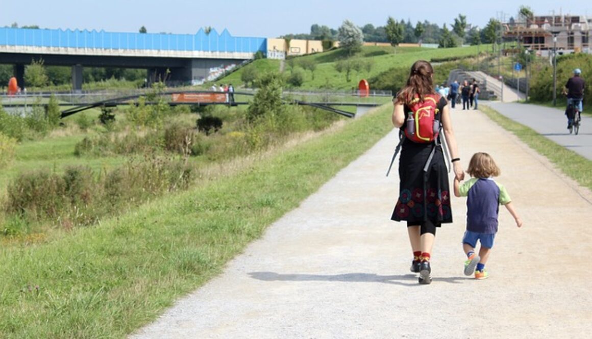 mamma che accompagna bambino a scuola di spalle
