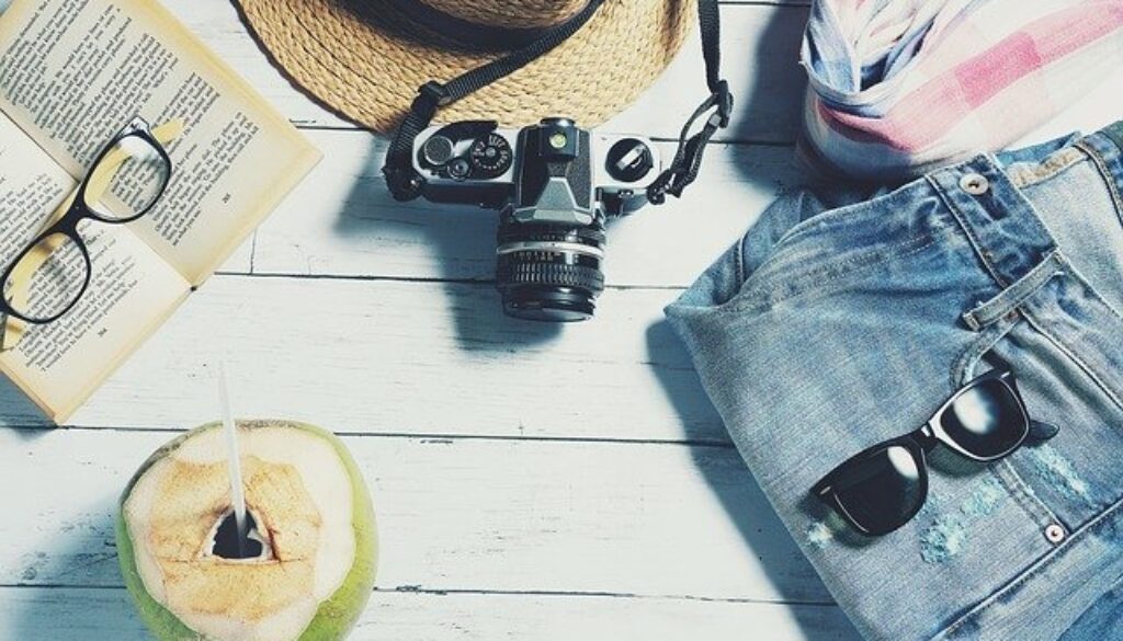macchina fotografica, cappello, occhiali da sole, libro