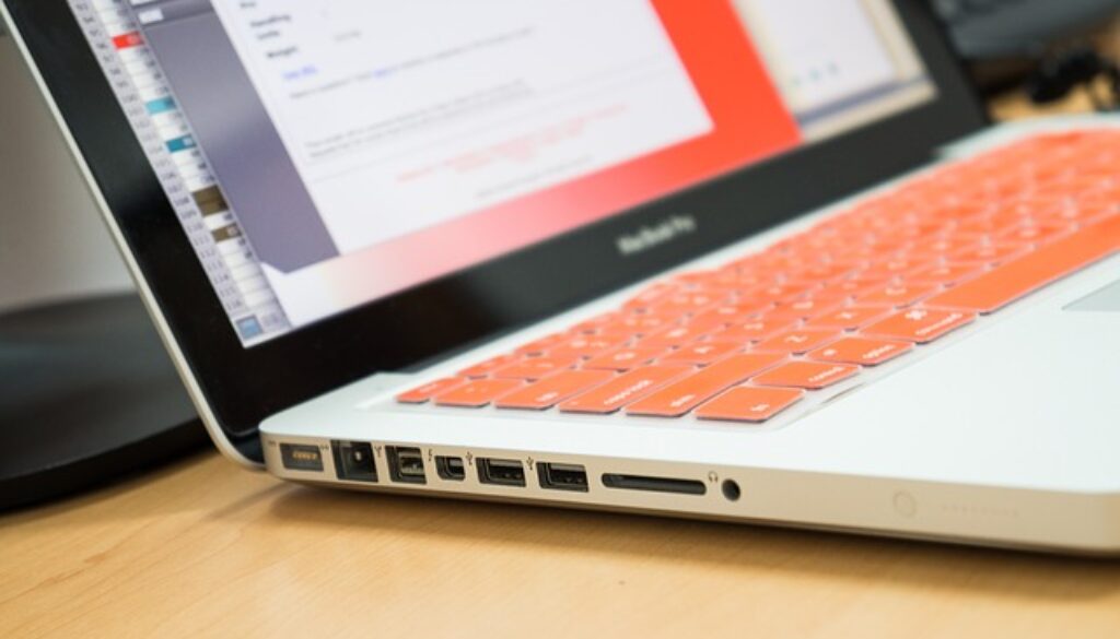 laptop con grafici e tastiera arancione