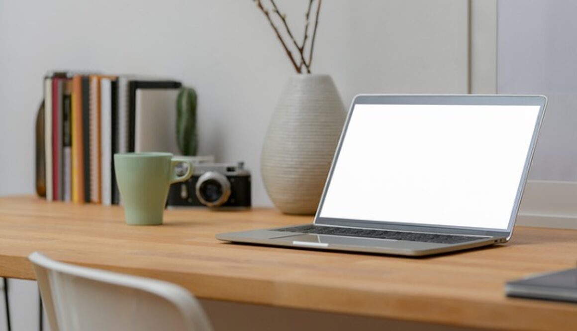 scrivania con laptop, vaso, mug
