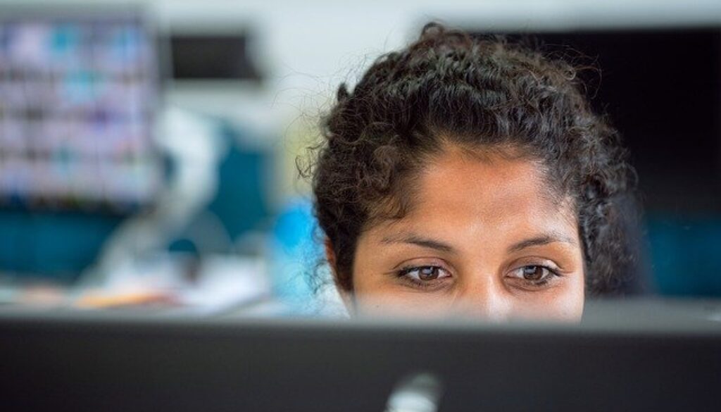 viso di ragazza dietro a schermo di pc