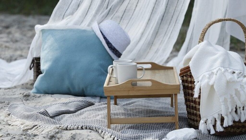 cuscino, tappeto e vassoio su una spiaggia