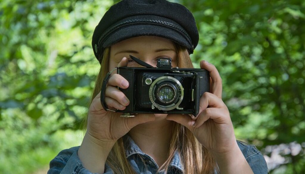 ragazza che fotografa con macchina vintage