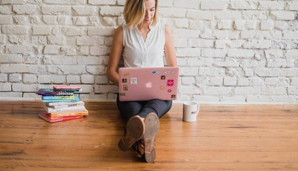 ragazza seduta per terra con computer portatile