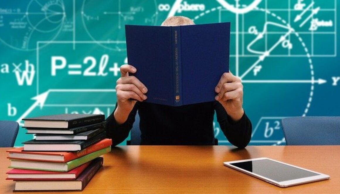 studente con libri e lavagna con calcoli matematici