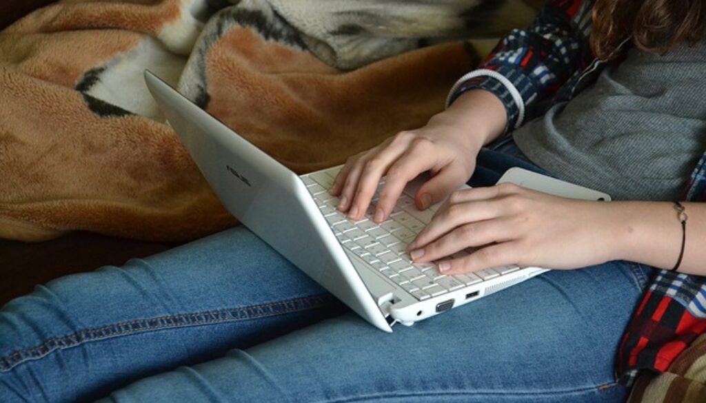 ragazza che scrive con laptop. cercare lavoro è un lavoro! Ti spieghiamo come fare
