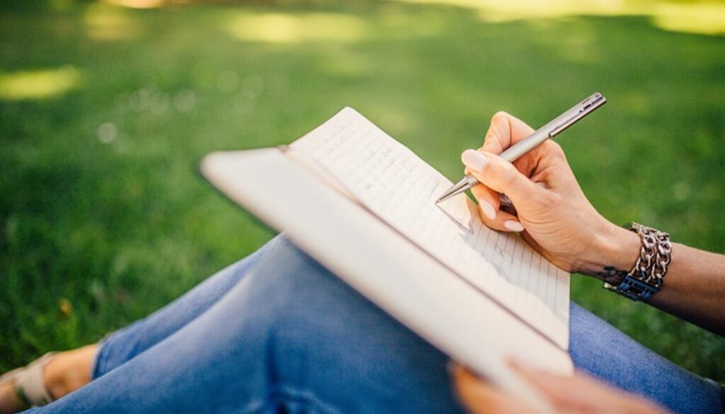 ragazza che scrive in un giardino