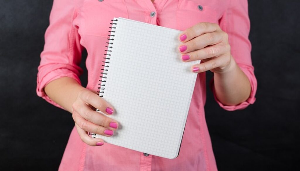 donna vestita di rosa con quaderno appunti