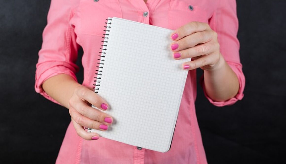 donna vestita di rosa con quaderno appunti