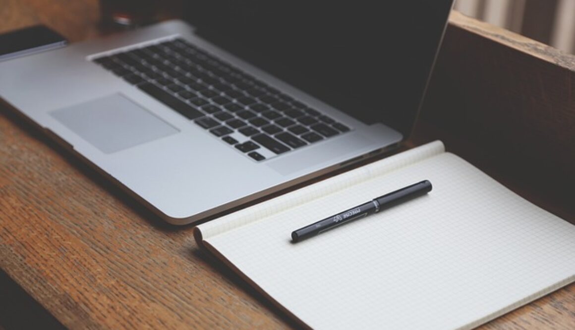 scrivania con computer e blocco appunti