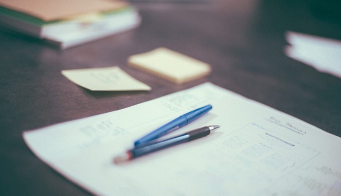 scrivania con fogli e penne