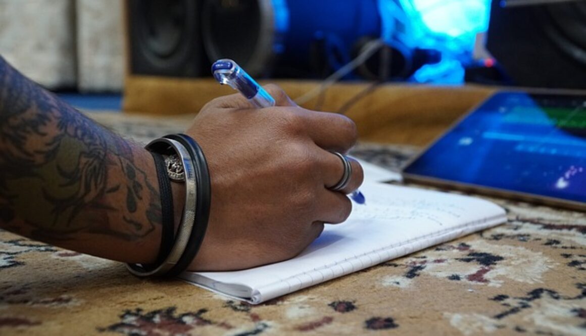 mano di ragazzo che scrive su un quaderno. Partecipa al premio letterario Malaguzzi