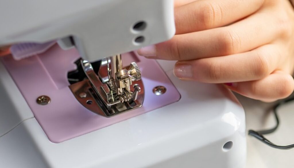 macchina da cucire e mano di una sarta. A Brescia un corso gratuito di sartoria