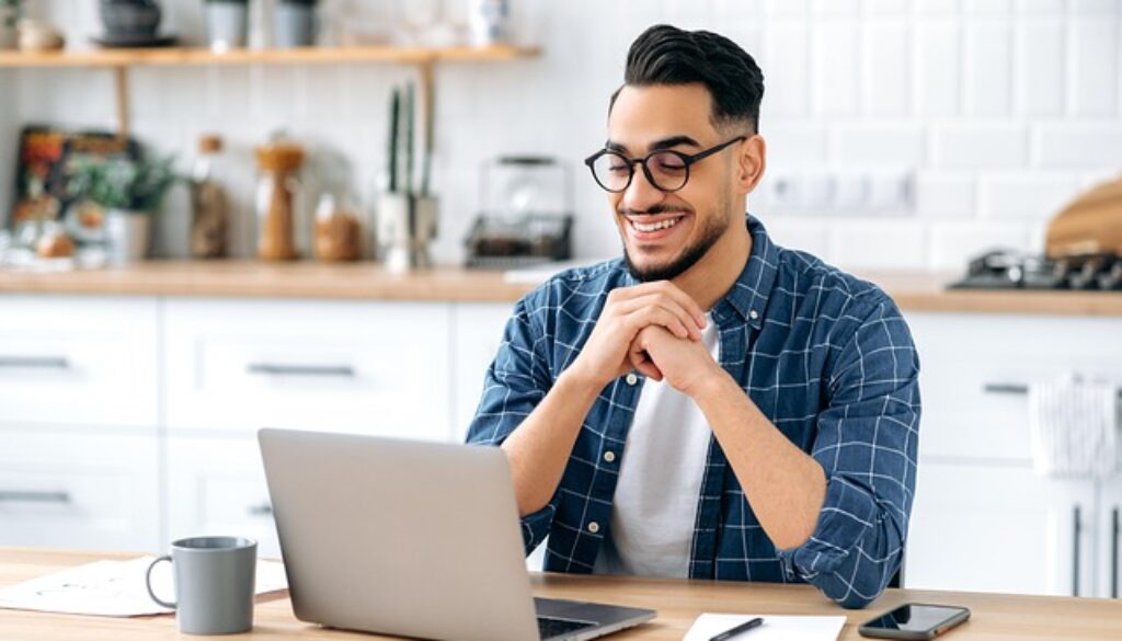 ragazzo con computer nella cucina di casa. Corsi online gratuiti in partenza da settembre