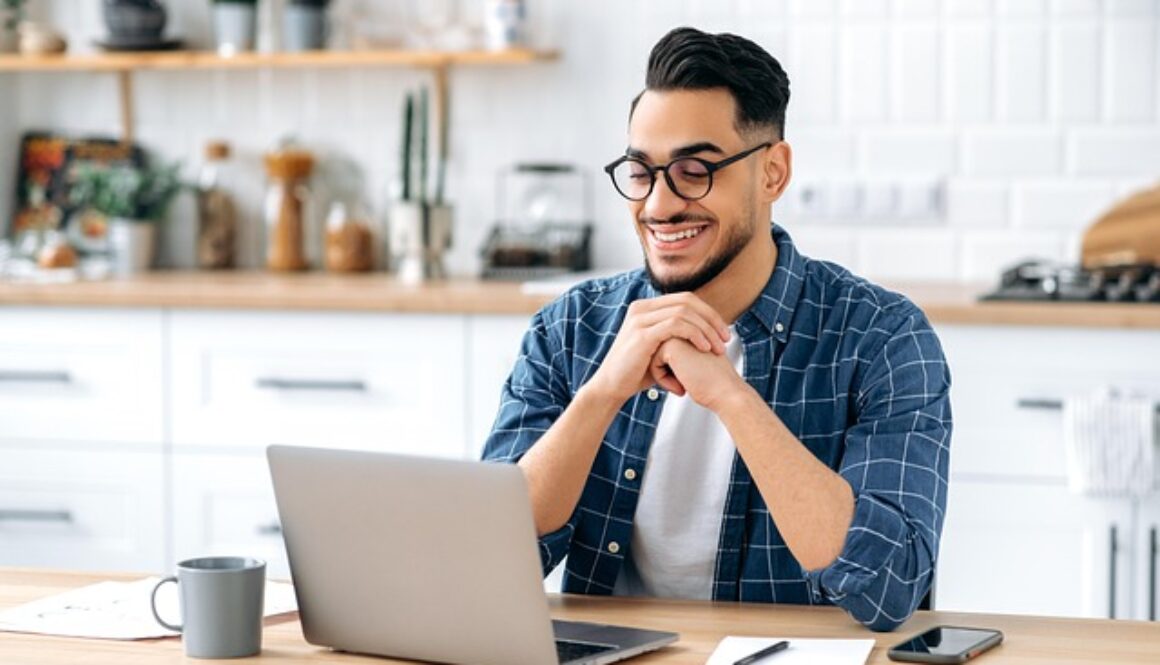 ragazzo con computer nella cucina di casa. Corsi online gratuiti in partenza da settembre